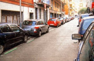 Calle con los coches aparcados en la acera, obligando a los peatones a ir por la carretera.